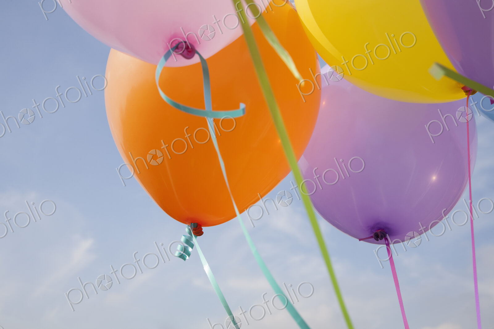 A group of coloured balloons floating in the air.