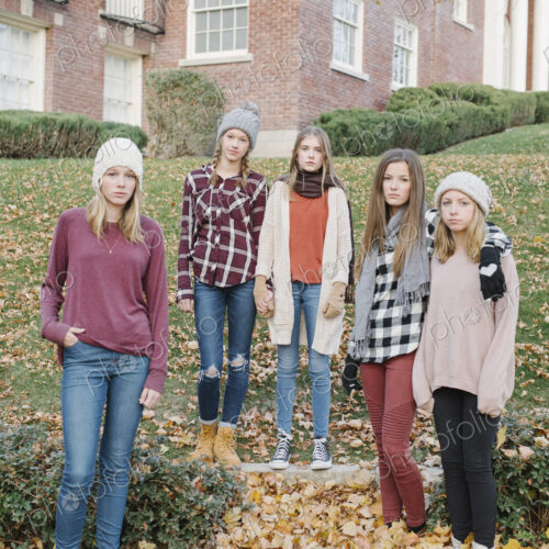A group of five teenage girls outdoors in woolly hats and scarves. A group of five teenage girls outdoors in woolly hats and scarves.