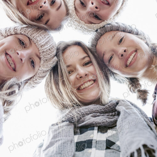 A group of five teenage girls outdoors in woolly hats and scarves. A group of five teenage girls outdoors in woolly hats and scarves.