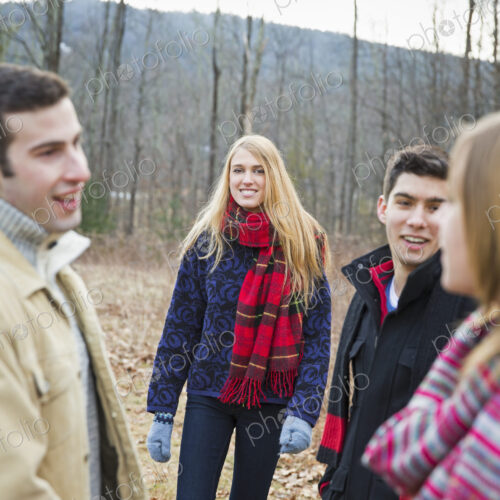 A group of four people outdoors on a winter day. A group of four people outdoors on a winter day.