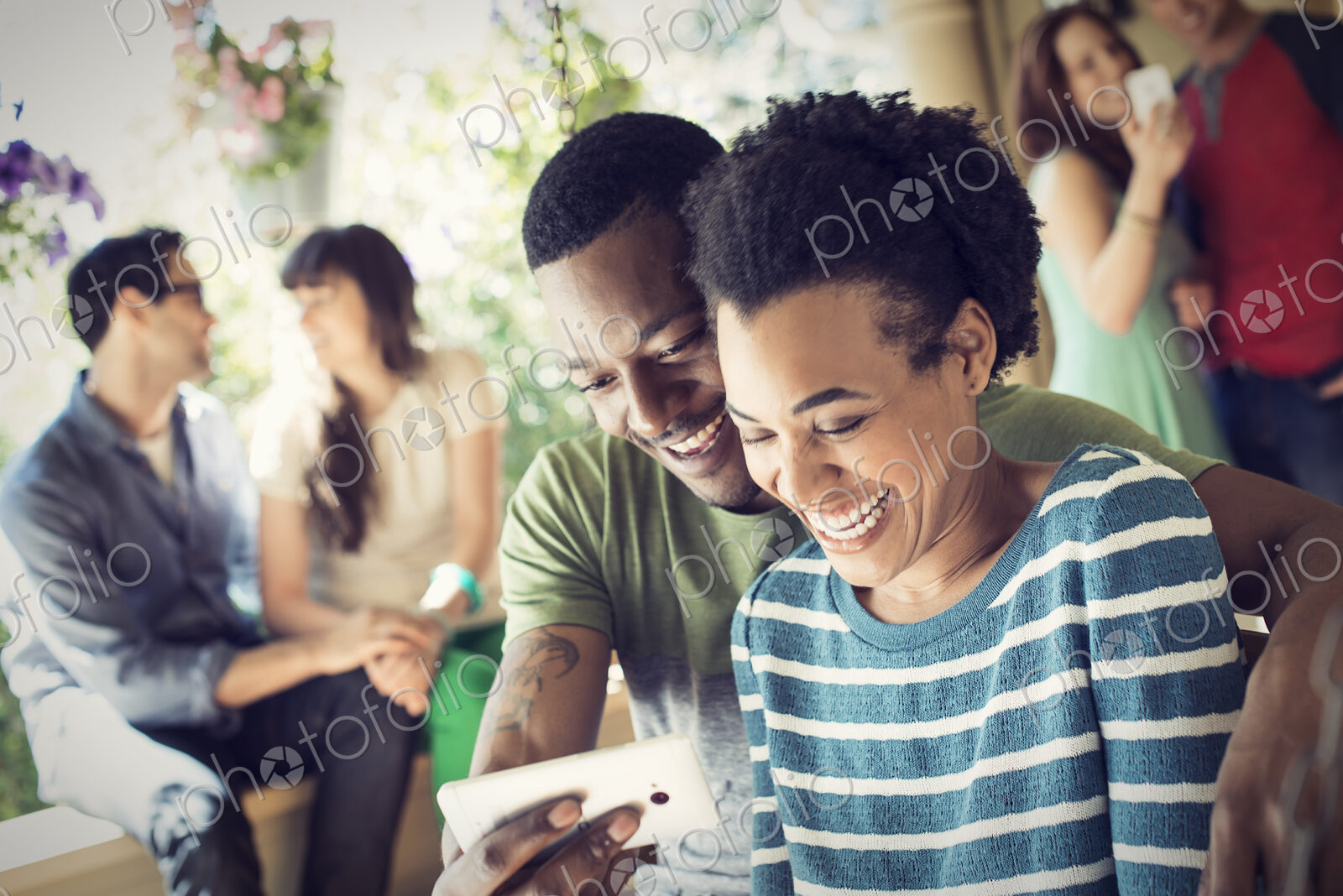 A group of friends, men and women at a house party. A couple taking a selfie.