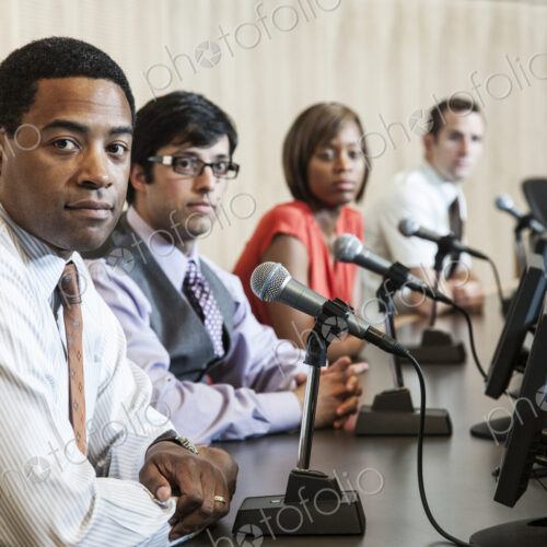 A group of men and a woman, an ethnically diverse panel of politicians sitting with… A group of men and a woman, an ethnically diverse panel of politicians sitting with…