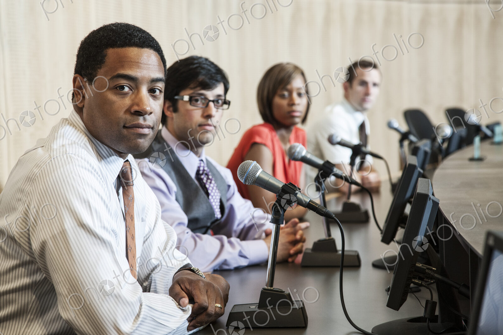 A group of men and a woman, an ethnically diverse panel of politicians sitting with…