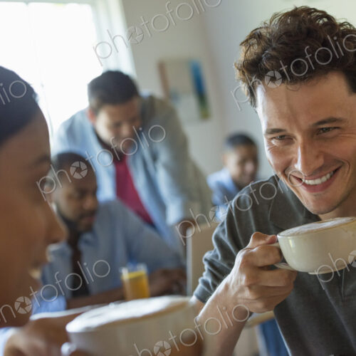 A group of men and women in a cafe, eating and drinking and enjoying each other's company. A group of men and women in a cafe, eating and drinking and enjoying each other's company.