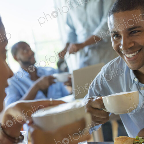 A group of men and women in a cafe, eating and drinking and enjoying each other's company. A group of men and women in a cafe, eating and drinking and enjoying each other's company.