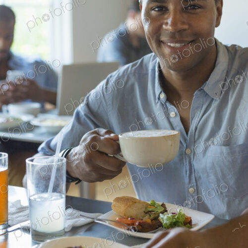 A group of men and women in a cafe, eating and drinking and enjoying each other's company. A group of men and women in a cafe, eating and drinking and enjoying each other's company.