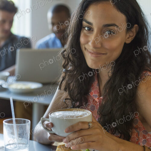 A group of men and women in a cafe, eating and drinking and enjoying each other's company. A group of men and women in a cafe, eating and drinking and enjoying each other's company.