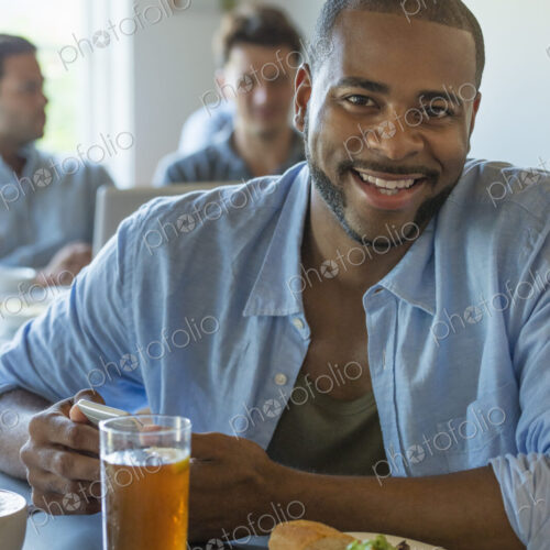 A group of men and women in a cafe, eating and drinking and enjoying each other's company. A group of men and women in a cafe, eating and drinking and enjoying each other's company.