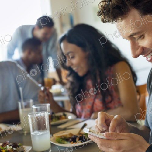 A group of men and women in a cafe, having drinks and enjoying each other's company. A group of men and women in a cafe, having drinks and enjoying each other's company.