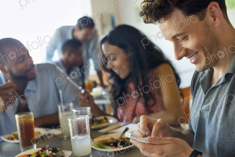 A group of men and women in a cafe, having drinks and enjoying each other's company.