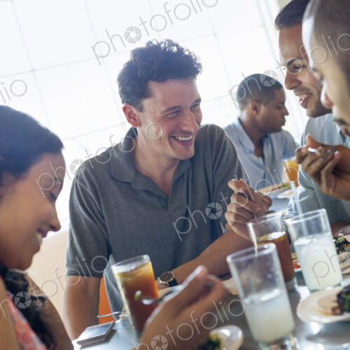 A group of men and women in a cafe, having drinks and enjoying each other's company. A group of men and women in a cafe, having drinks and enjoying each other's company.