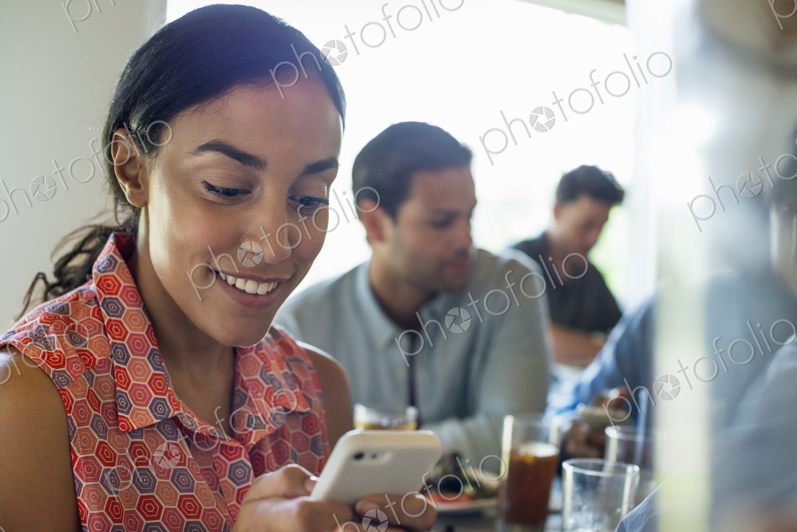 A group of men and women in a cafe, having drinks and enjoying each other’s company.