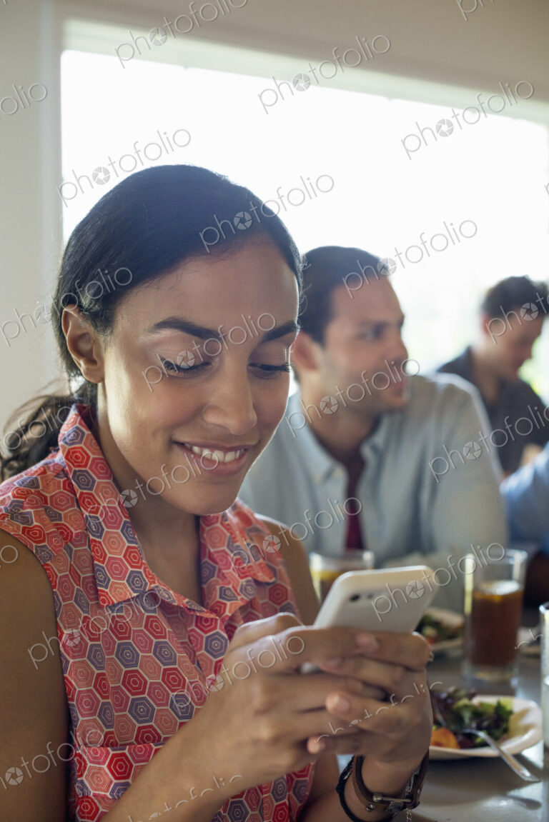 A group of men and women in a cafe, having drinks and enjoying each other's company.