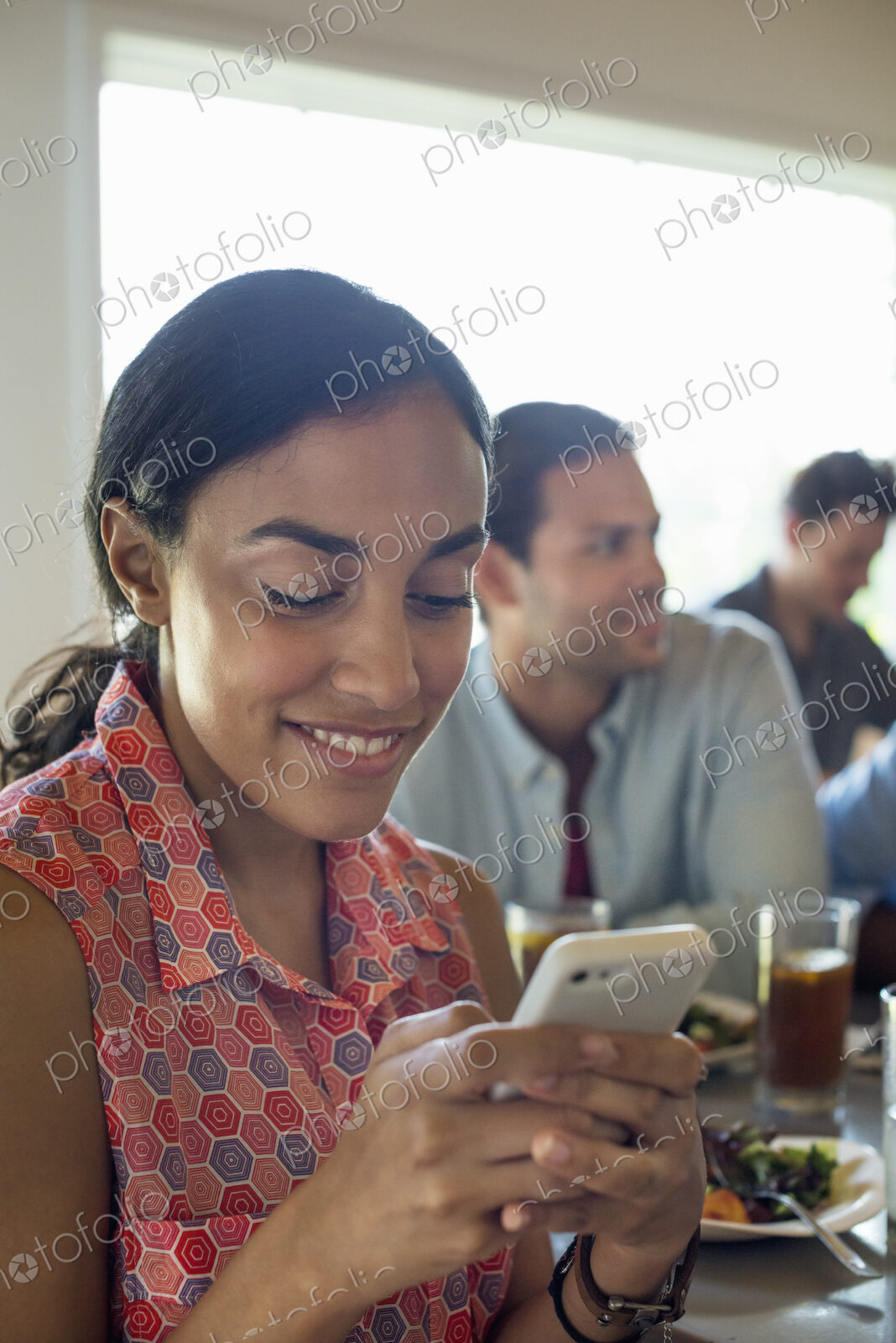 A group of men and women in a cafe, having drinks and enjoying each other’s company.