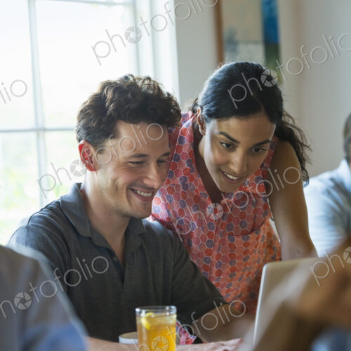 A group of men and women in a cafe, having drinks and enjoying each other's company. A group of men and women in a cafe, having drinks and enjoying each other's company.