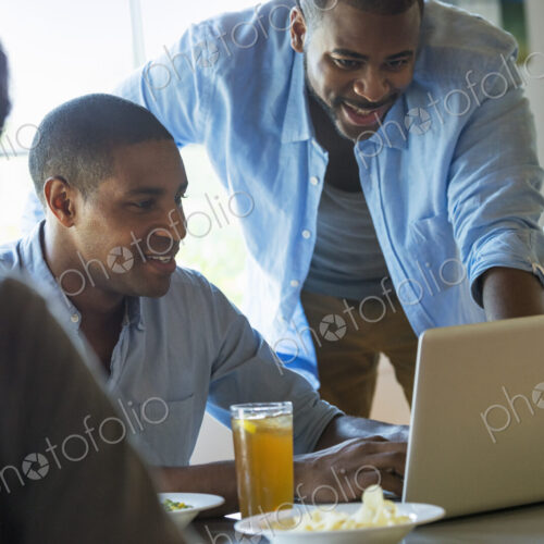 A group of men and women in a cafe, having drinks and enjoying each other's company. A group of men and women in a cafe, having drinks and enjoying each other's company.