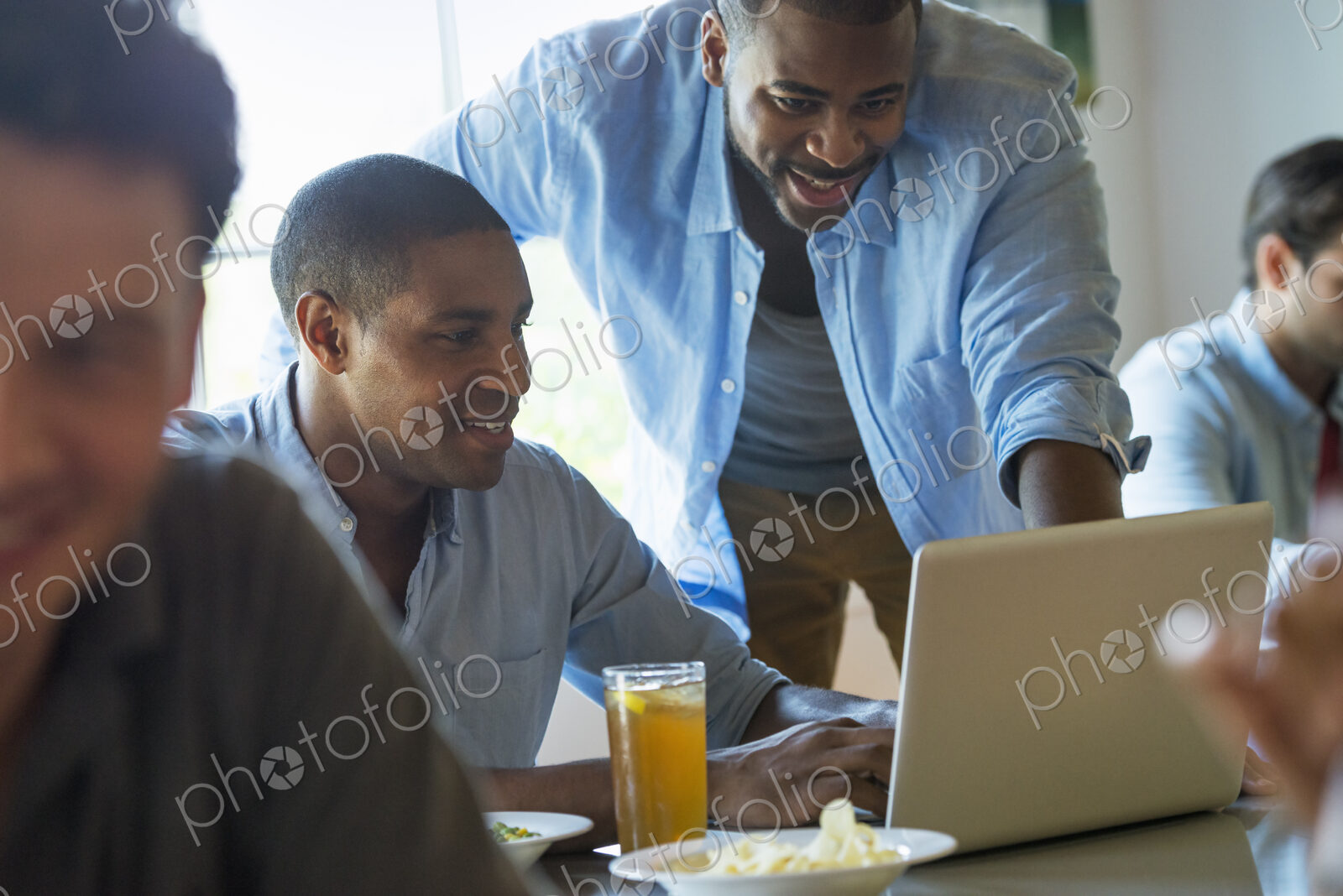 A group of men and women in a cafe, having drinks and enjoying each other’s company.