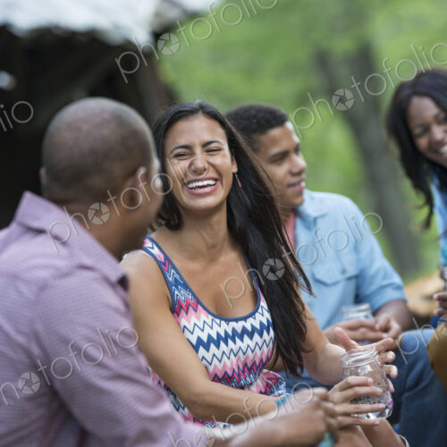 A group of men and women outdoors enjoying themselves. A group of men and women outdoors enjoying themselves.