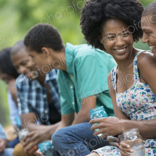 A group of men and women outdoors enjoying themselves. A group of men and women outdoors enjoying themselves.