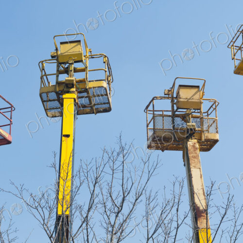 A group of mobile cranes with hooks and pulleys, dockyard lifting equipment.