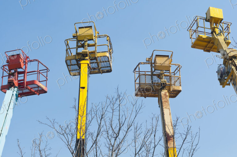 A group of mobile cranes with hooks and pulleys, dockyard lifting equipment.