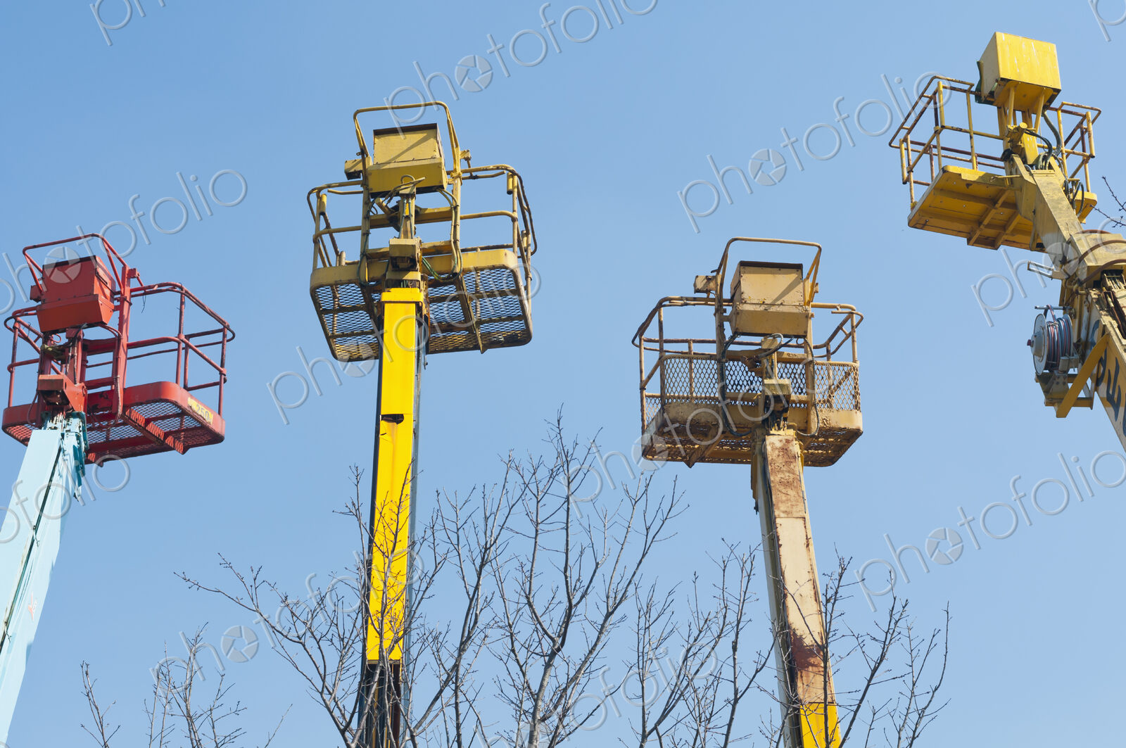 A group of mobile cranes with hooks and pulleys, dockyard lifting equipment.