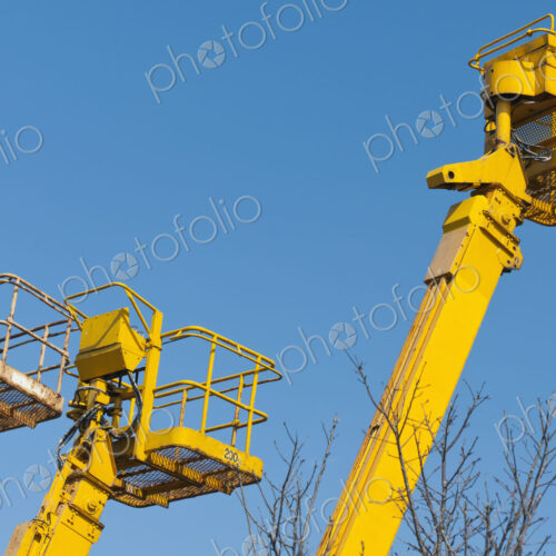 A group of mobile cranes with hooks and pulleys, dockyard lifting equipment.