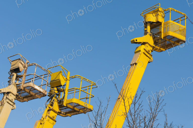 A group of mobile cranes with hooks and pulleys, dockyard lifting equipment.