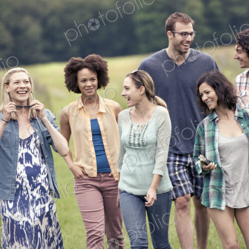 A group of people, a man and five women, walking through the countryside.