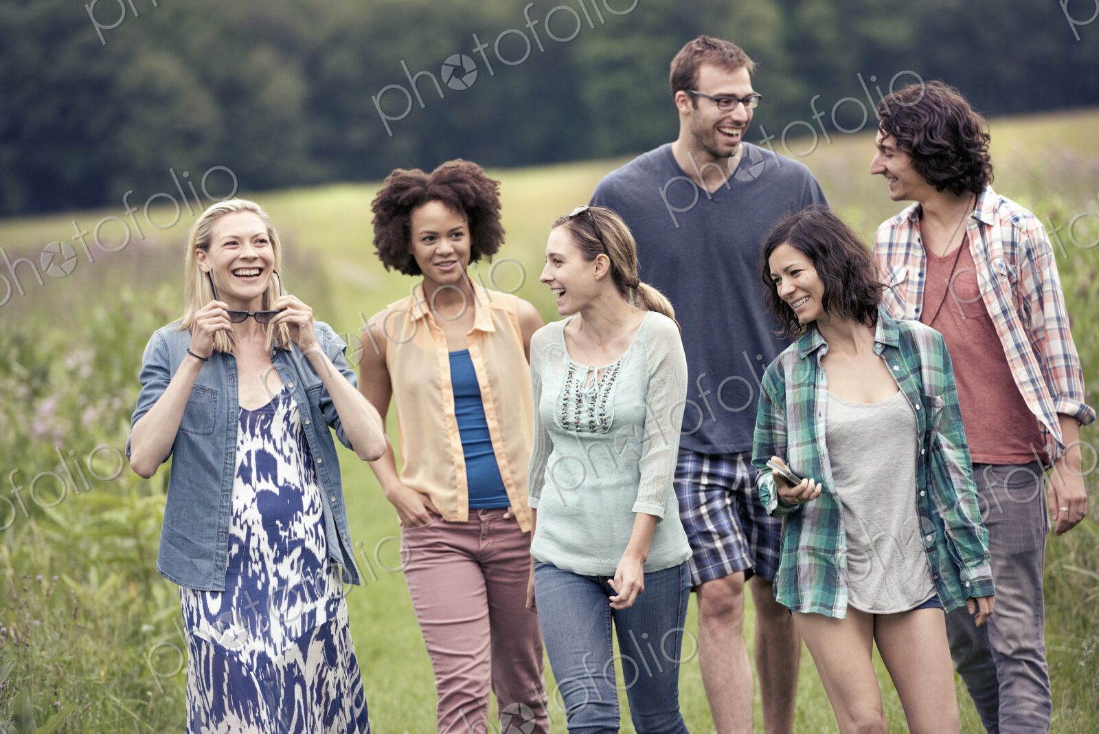 A group of people, a man and five women, walking through the countryside.