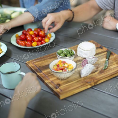 A group of people gathered around a table with a buffet laid out A group of people gathered around a table with a buffet laid out