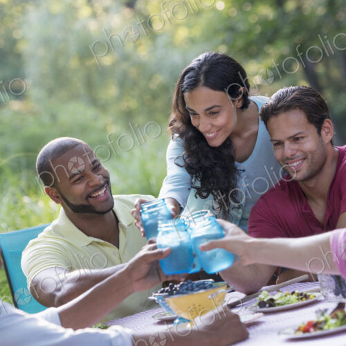 A group of people having a meal outdoors, a picnic. Men and women. A group of people having a meal outdoors, a picnic. Men and women.