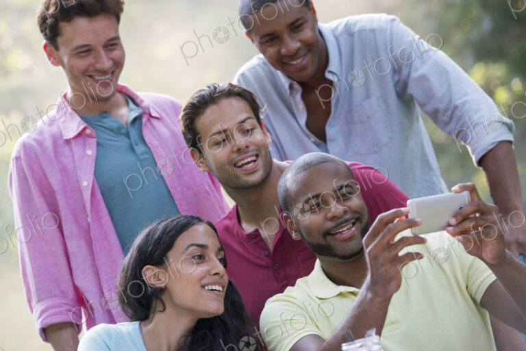 A group of people having a meal outdoors, a picnic. Men and women.