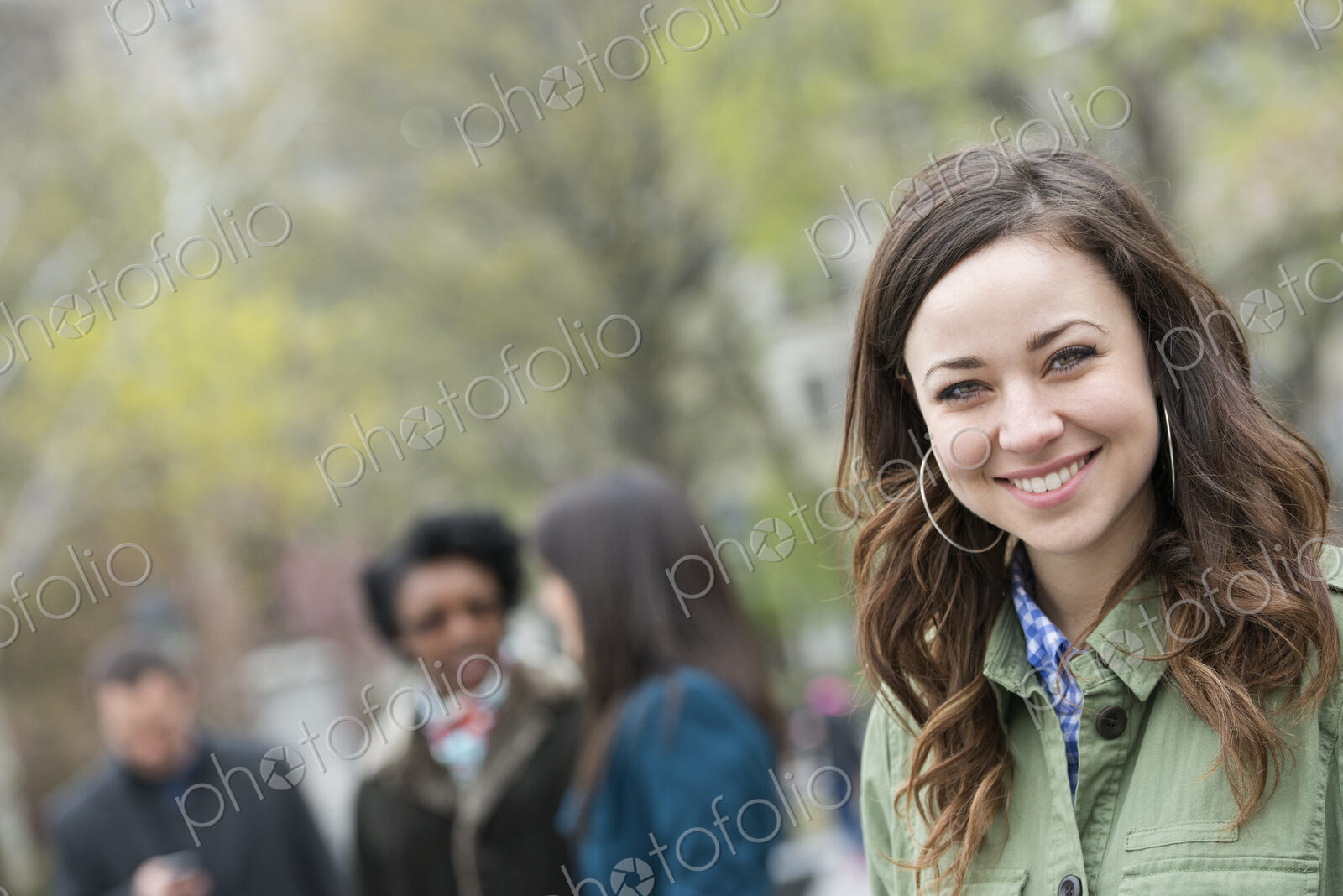 A group of people in the park. A young woman in an open necked shirt, smiling and…