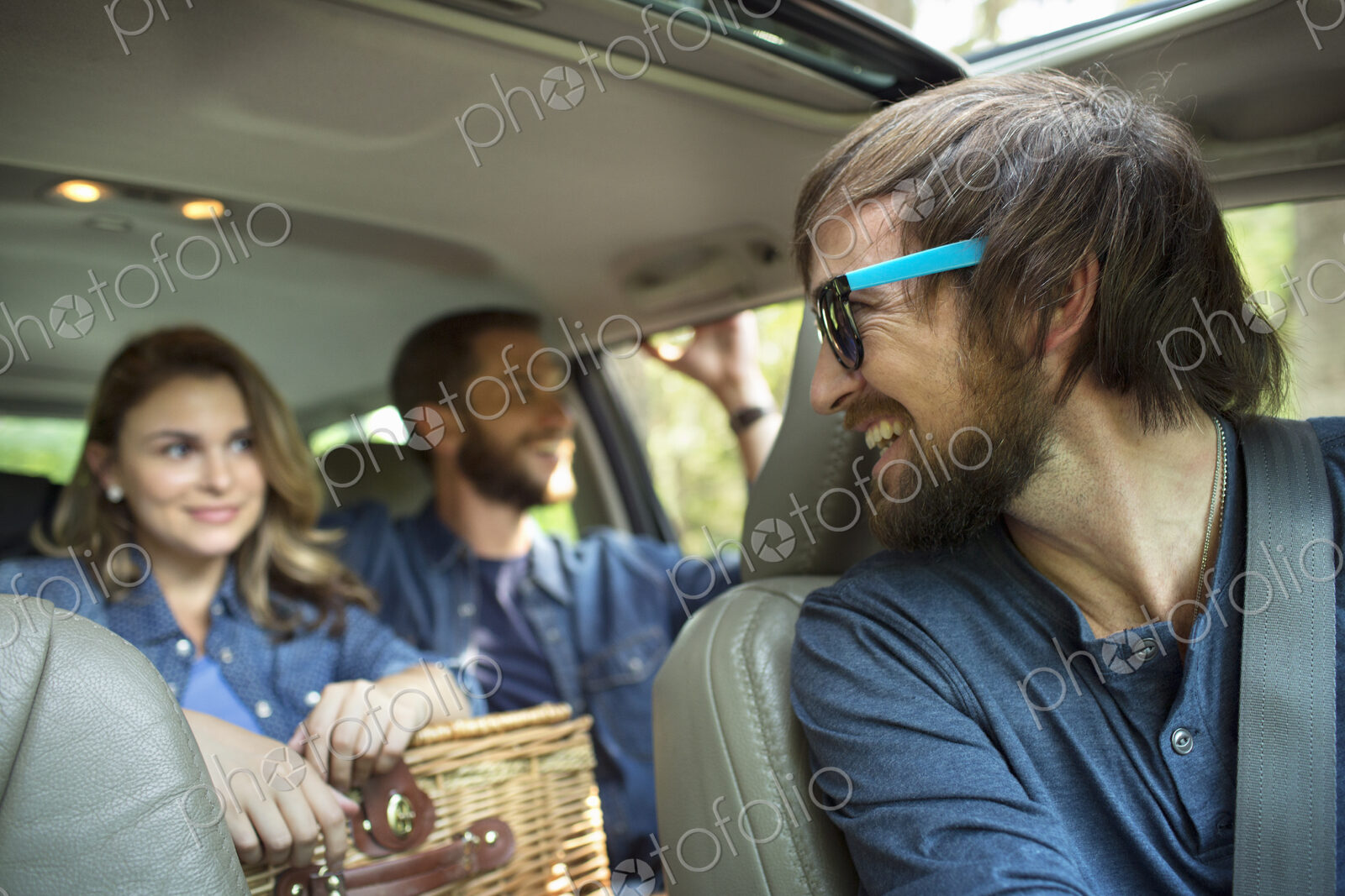 A group of people inside a car, on a road trip.