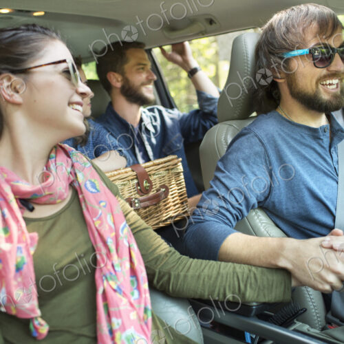 A group of people inside a car, on a road trip.