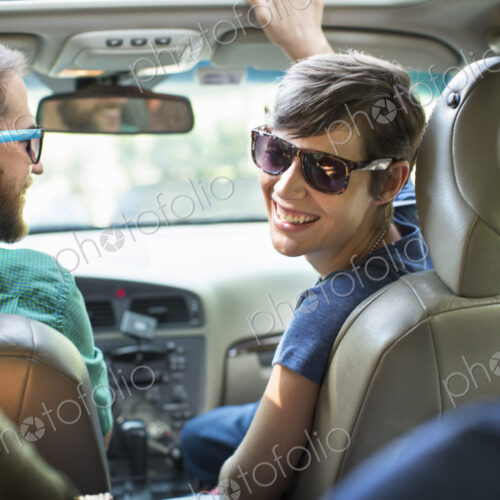 A group of people inside a car, on a road trip. View from the back seat. A group of people inside a car, on a road trip. View from the back seat.