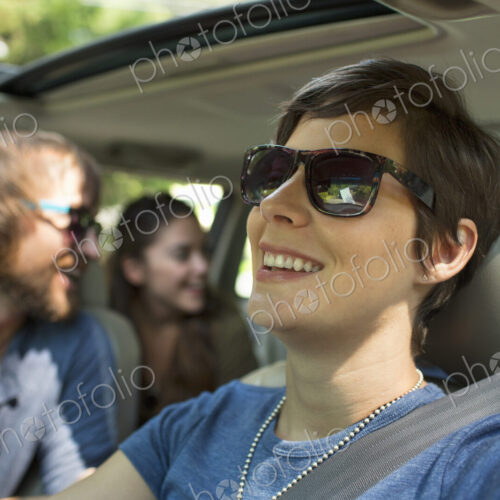 A group of people inside a car, on a road trip. View to the back seat, four passengers. A group of people inside a car, on a road trip. View to the back seat, four passengers.