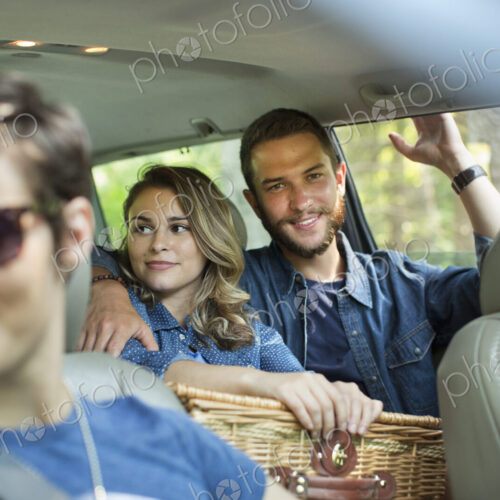 A group of people inside a car, two in the back seat and two in the front. A group of people inside a car, two in the back seat and two in the front.