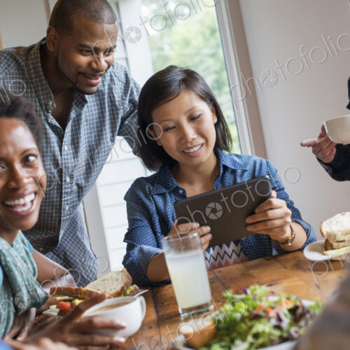 A group of people meeting in a cafe for a meal. Using digital tablets and smart phones. A group of people meeting in a cafe for a meal. Using digital tablets and smart phones.