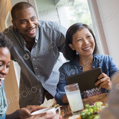 A group of people meeting in a cafe for a meal. Using digital tablets and smart phones. A group of people meeting in a cafe for a meal. Using digital tablets and smart phones.