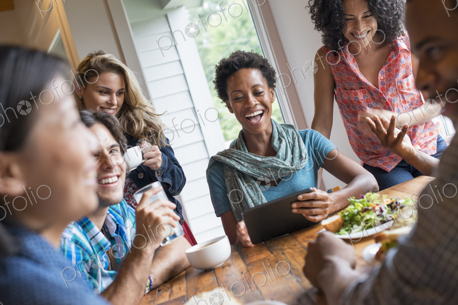 A group of people meeting in a cafe. Using digital tablets and smart phones. Having a…
