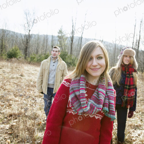 A group of three people, a man and two women, on a walk on a winter day. A group of three people, a man and two women, on a walk on a winter day.