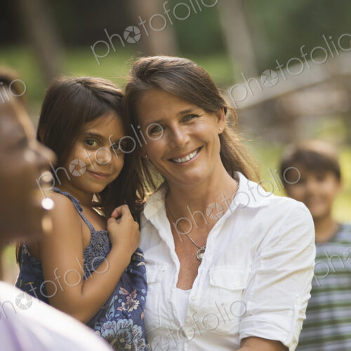 A group of women and children outdoors, laughing and smiling.