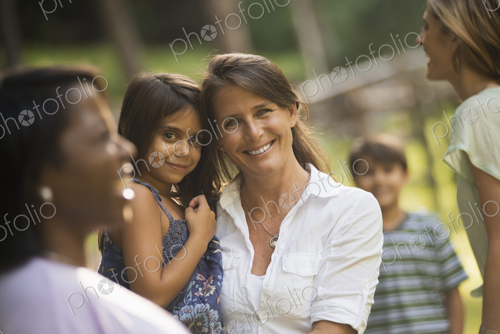 A group of women and children outdoors, laughing and smiling.