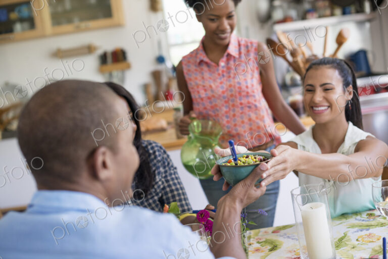 A group of women and men at a meal in a farmhouse kitchen.
