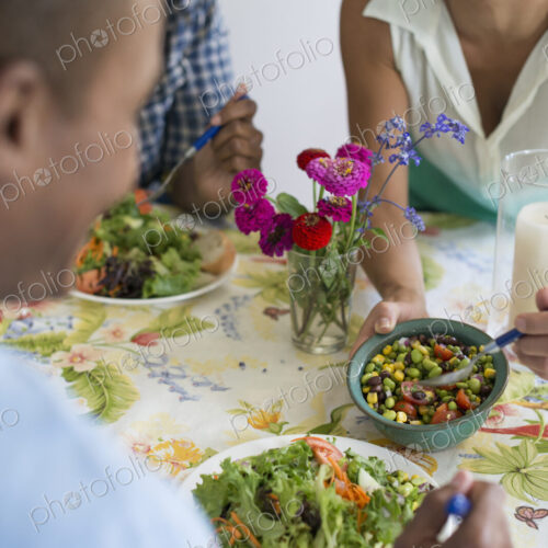 A group of women and men at a meal in a farmhouse kitchen.