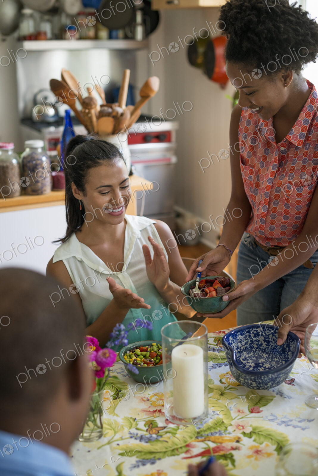 A group of women and men at a meal in a farmhouse kitchen.