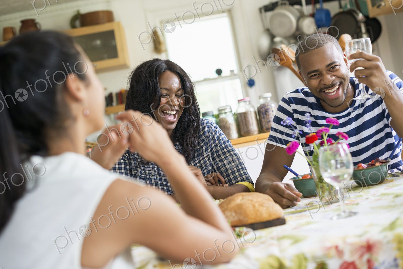 A group of women and men at a meal in a farmhouse kitchen.