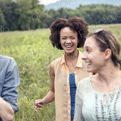 A group of women walking through a meadow in the countryside laughing. A group of women walking through a meadow in the countryside laughing.